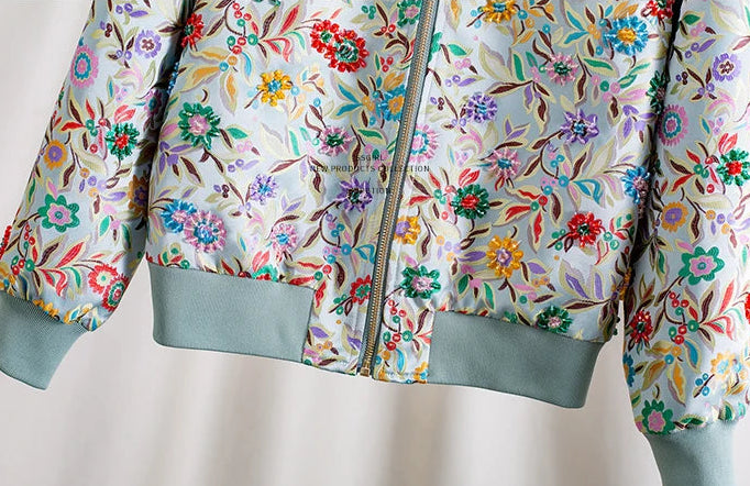 Bomber jacket with colorful floral embroidery and green cuffs, featuring a zipper closure | SuzzaneMarket