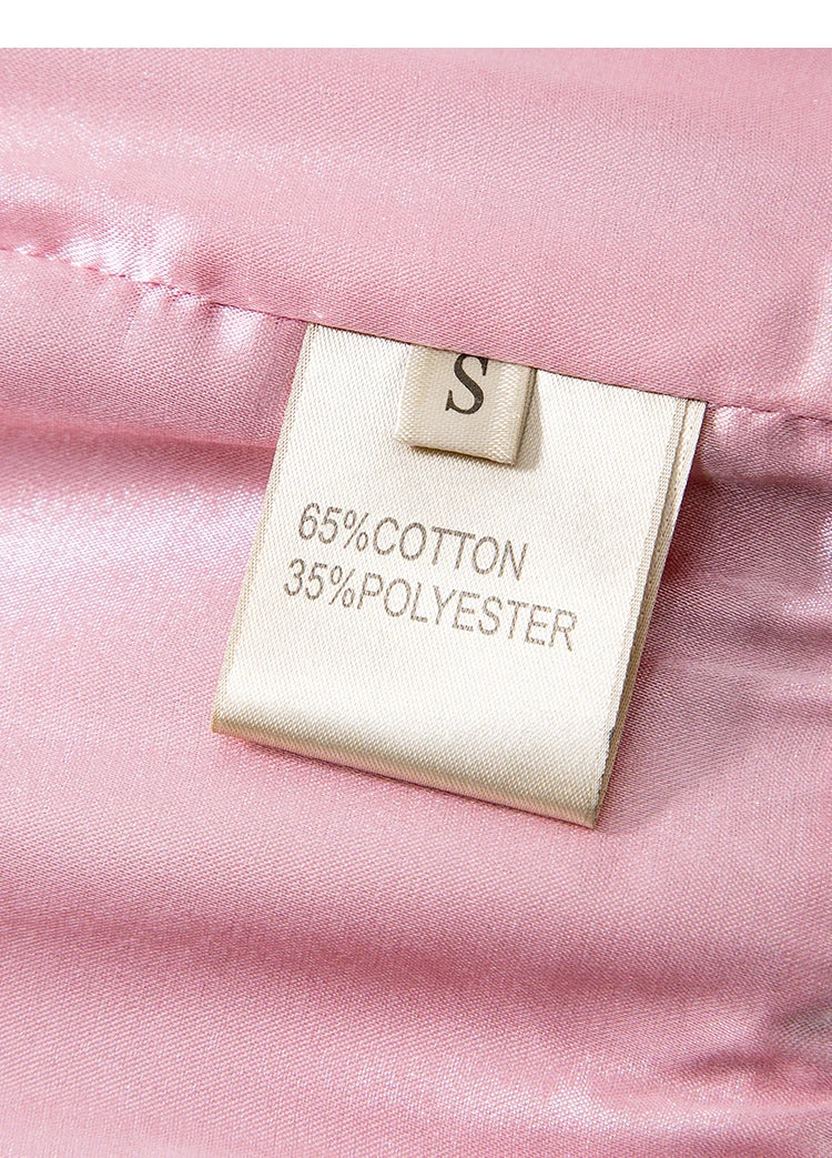 Close-up of care label on pink fabric, showing 65% cotton and 35% polyester composition | SuzzaneMarket