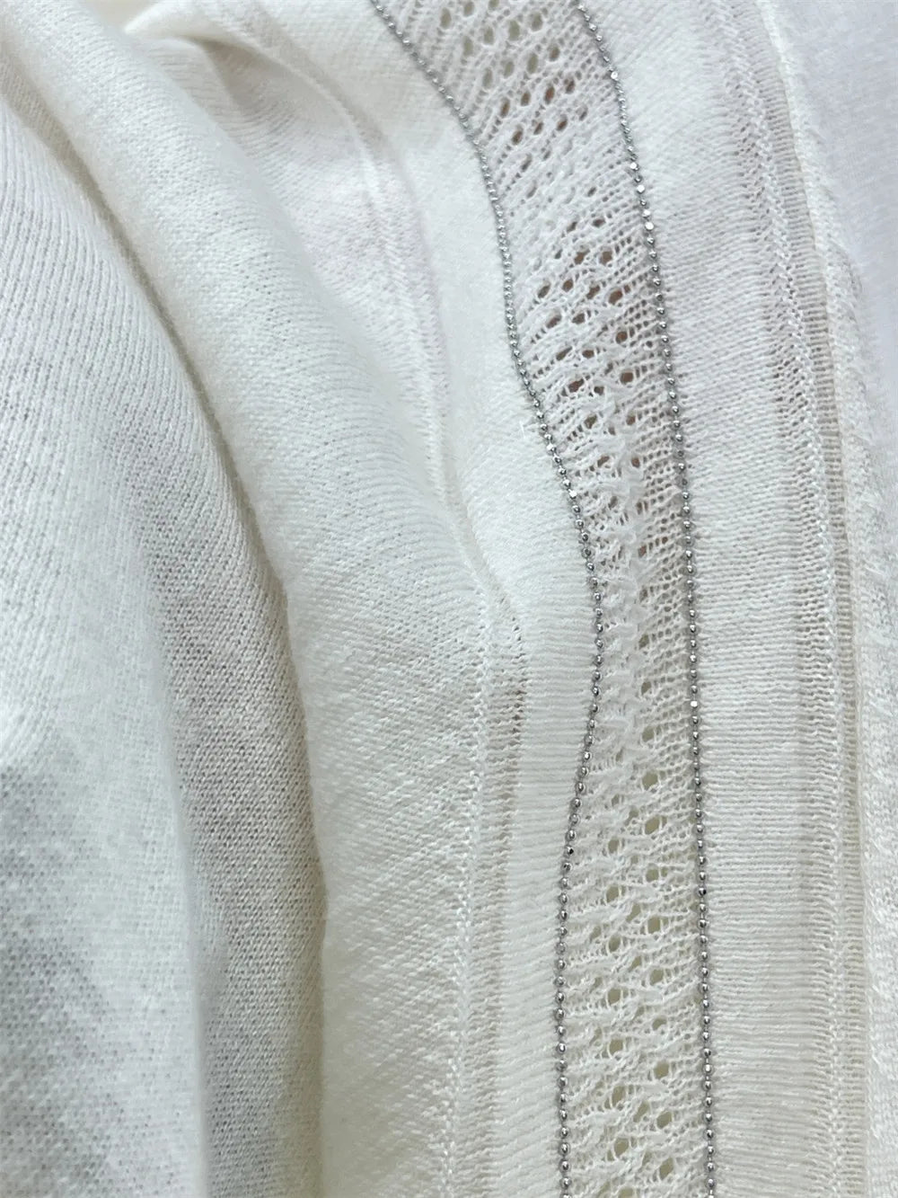 Close-up of a white cardigan featuring delicate lace details and soft texture | SuzzaneMarket