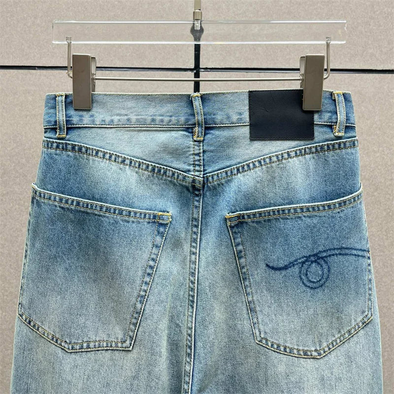 Back view of Y2K high-waisted jeans in light denim featuring wide legs and unique stitching. |SuzzaneMarket