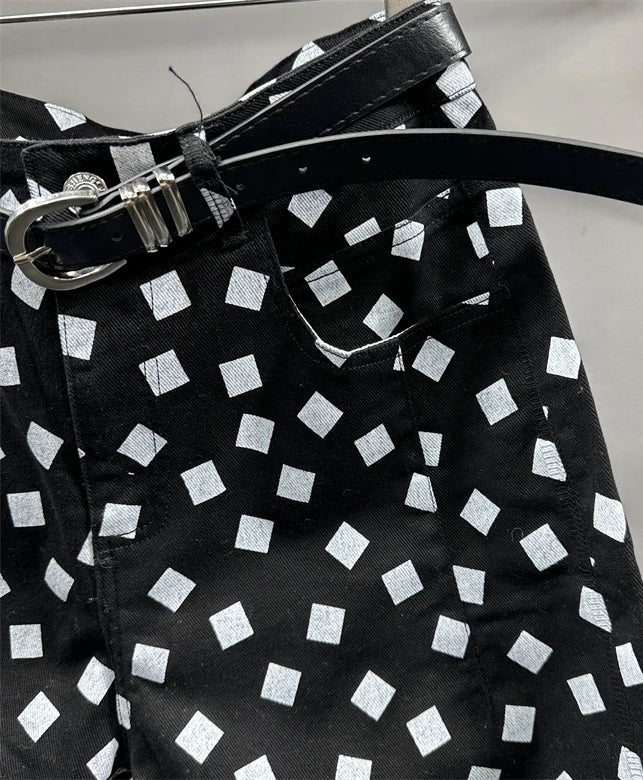 Close-up of printed black denim jeans with a high waist and slim fit, featuring a dark belt | SuzzaneMarket