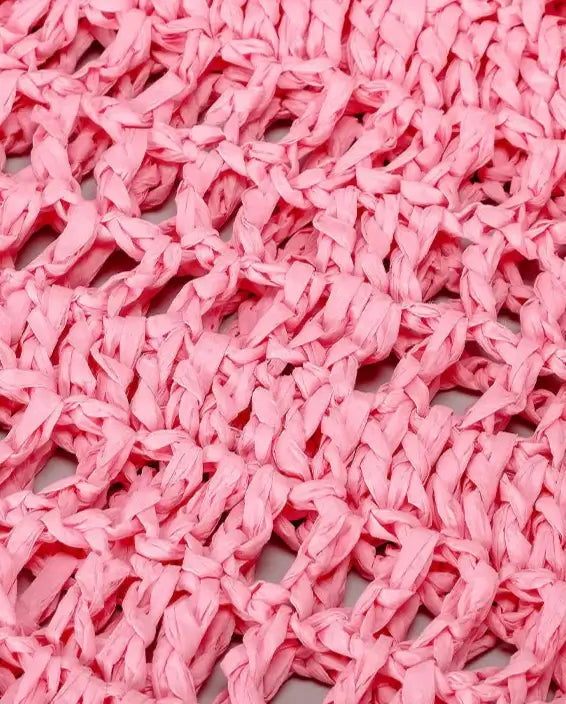 Close-up of pink woven straw material for the Grand Fourre-tout Paille by PALLI, showcasing its intricate texture.