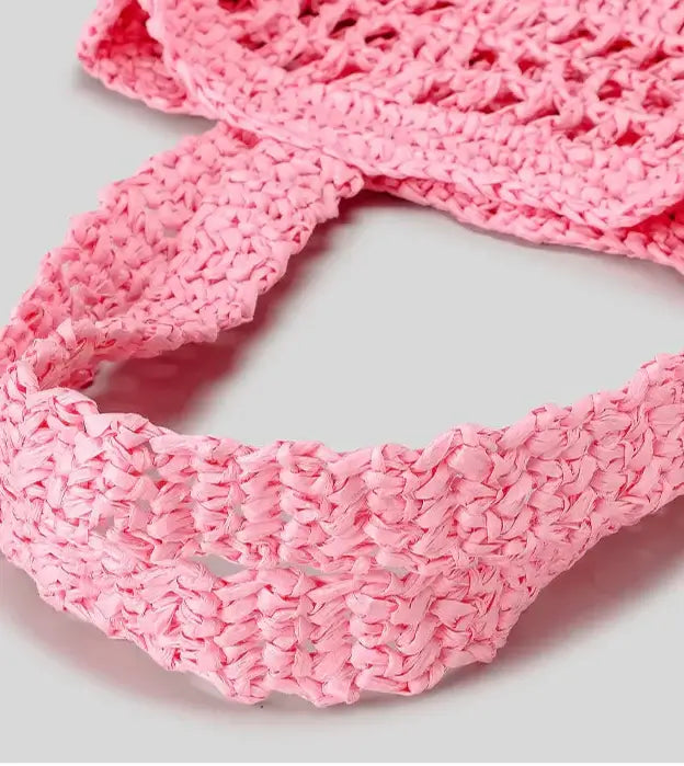 Close-up of the pink woven strap of the Grand Fourre-tout Paille by PALLI, showcasing its braided texture.