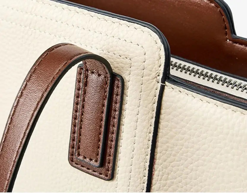 Close-up of the Sac Tote Cuir Grainé, showcasing its textured beige leather and contrasting brown handles.