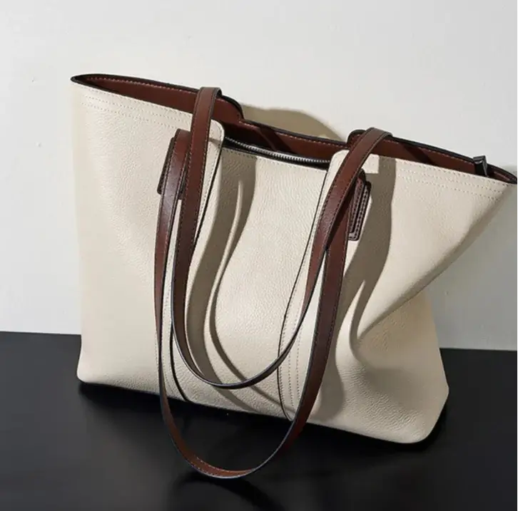 Grand Sac Tote Cuir Grainé beige avec anses en cuir marron et fermeture zipper, idéal pour un style élégant.