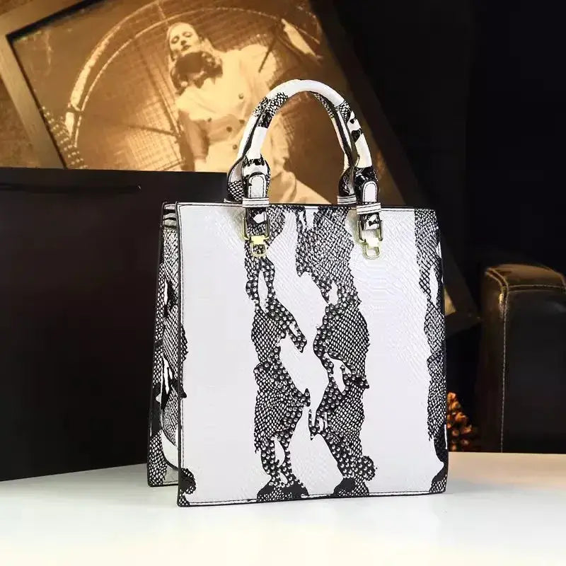 Sac Tote en cuir texturé noir et blanc, design rigide, deux poignées. Disponible sur SuzzaneMarket.