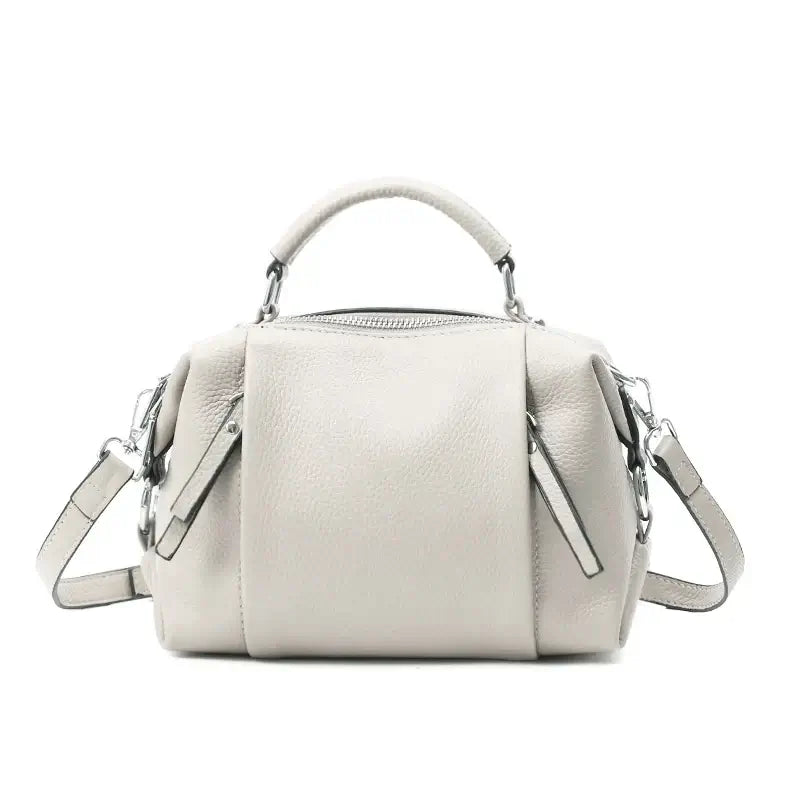 Sac Boston en cuir grainé beige avec double poche intérieure et poches extérieures avant et arrière.
