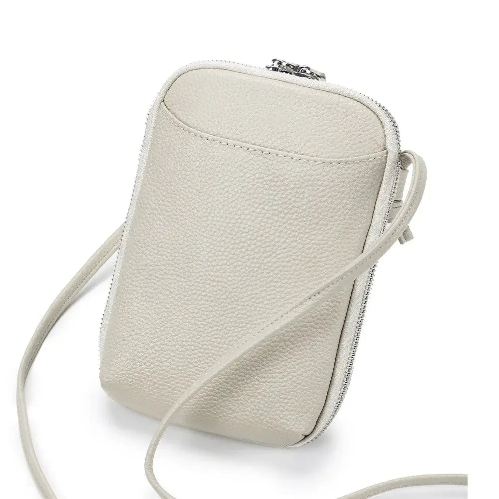 Sac pochette cuir grainé beige avec bandoulière, double zipper et poche extérieure, pratique pour l'essentiel.