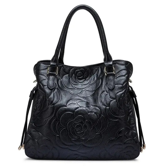 Sac tote en cuir frappé noir avec motif floral, poignées doubles et plusieurs poches intérieures.