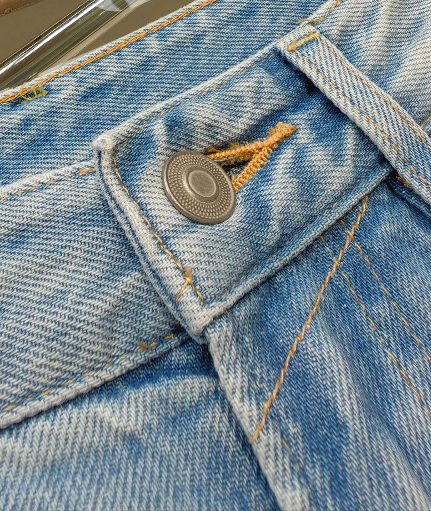 Close-up of classic straight-cut jeans with button detail and blue denim texture | SuzzaneMarket