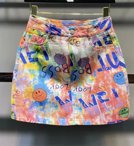 Colorful denim mini skirt with graphic print and high waist. Features pockets. Perfect for casual style | SuzzaneMarket.