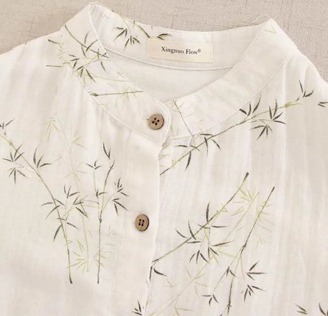 Close-up of a white robe collar with bamboo embroidery and wooden buttons | SuzzaneMarket