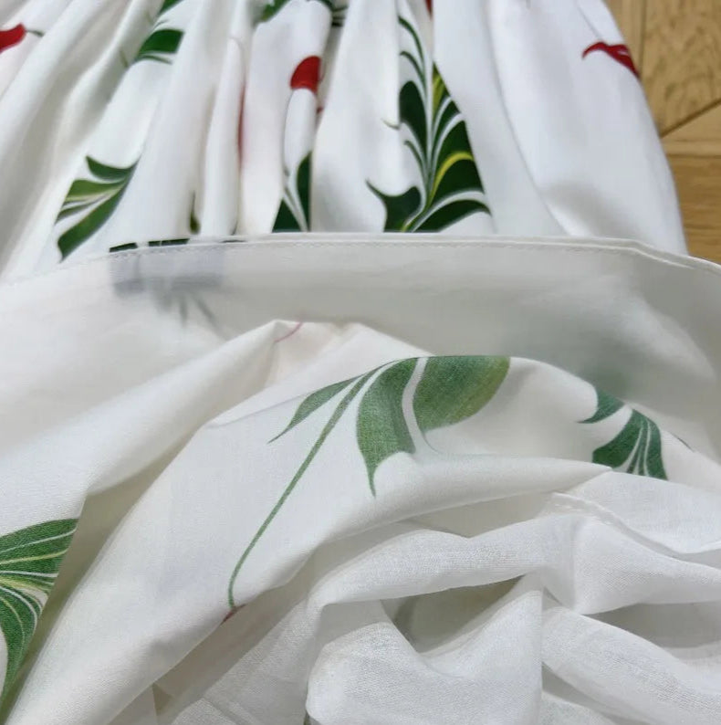 Zoomed view of the floral poplin fabric on Robe Florale Popeline - LINO - featuring green leaves and red accents | SuzzaneMarket