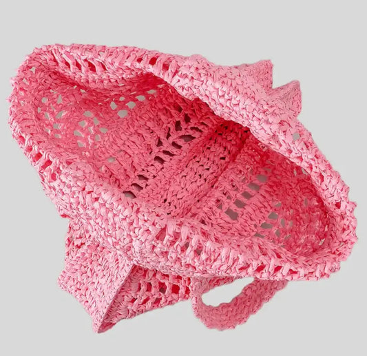 Grand sac en paille tressée ouvert en couleur rose, idéal pour les sorties et les journées à la plage.