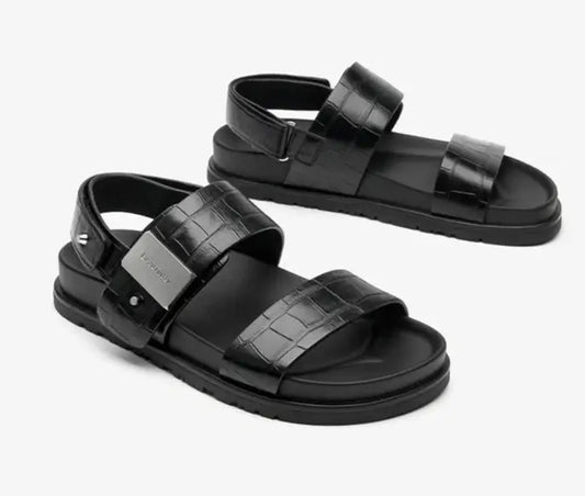 Sandales Gladiator en cuir frappé noir, large brides et talon réglable. Disponibles sur SuzzaneMarket.