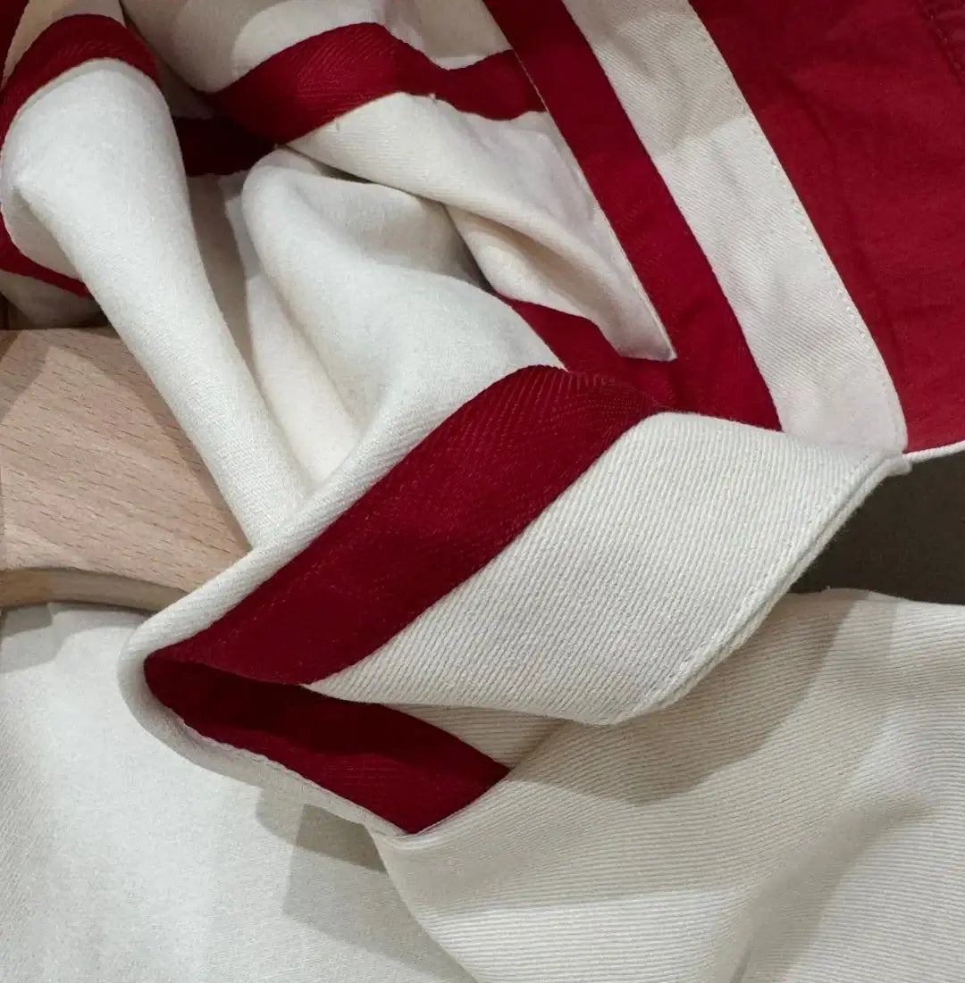 Close-up of a fabric with white and red stripes, showcasing its texture and design | SuzzaneMarket