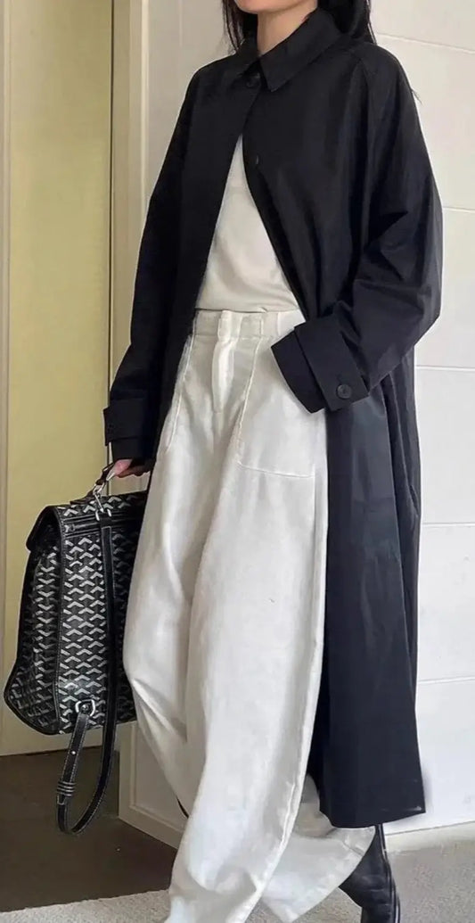 Elegant black trench coat with a straight cut, paired with white wide-leg pants | SuzzaneMarket