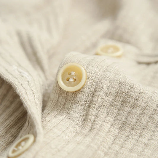 Close-up of soft cotton spandex T-shirt fabric with cream buttons | SuzzaneMarket