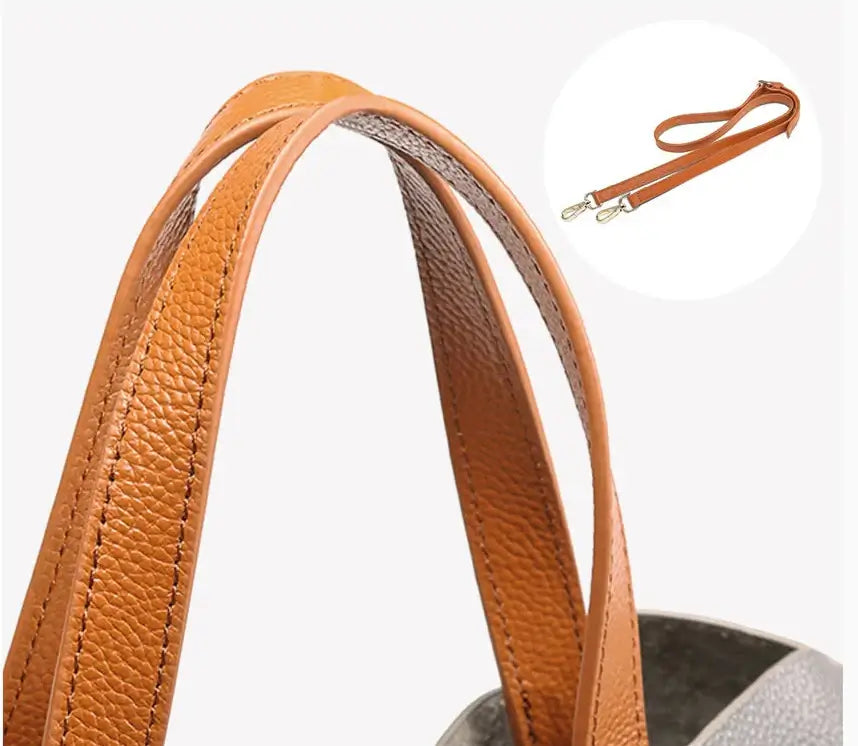 Detail of leather shopping bag handles and detachable shoulder strap, showcasing soft grain texture.
