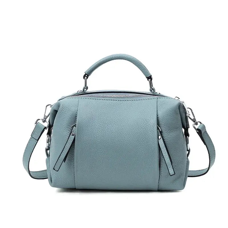 Sac Boston en cuir grainé couleur bleu clair, avec double poche intérieure et poches extérieures pratiques.