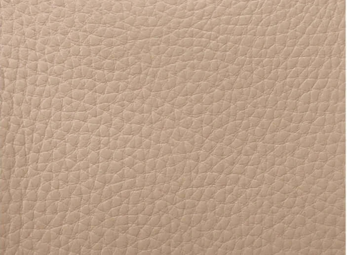 Close-up of beige textured leather, showcasing fine grain detail, ideal for luxury bags and accessories.