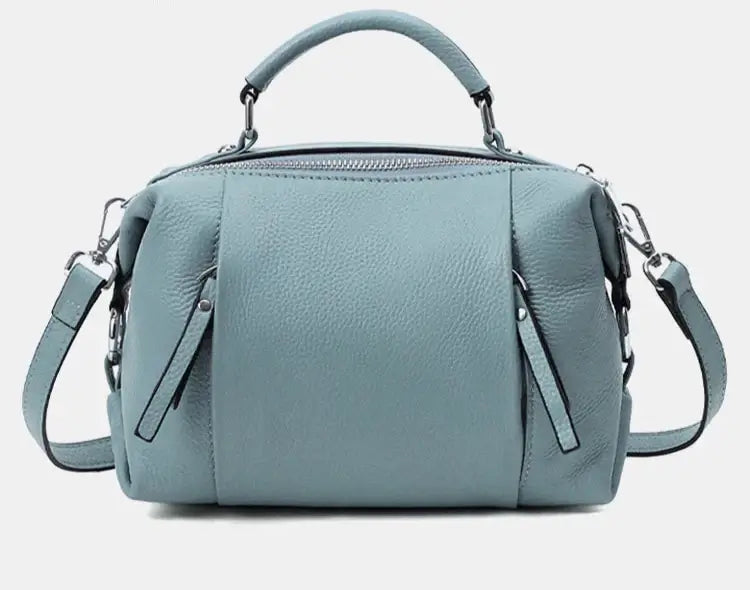 Sac Boston Cuir Grainé en vert, avec double poche intérieure et poches extérieures avant/arrière, design mi-souple.