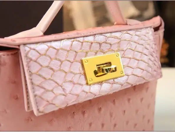 Sac rétro en cuir autruche rose avec fermeture dorée, élégant et bien fini. Disponible chez SuzzaneMarket.