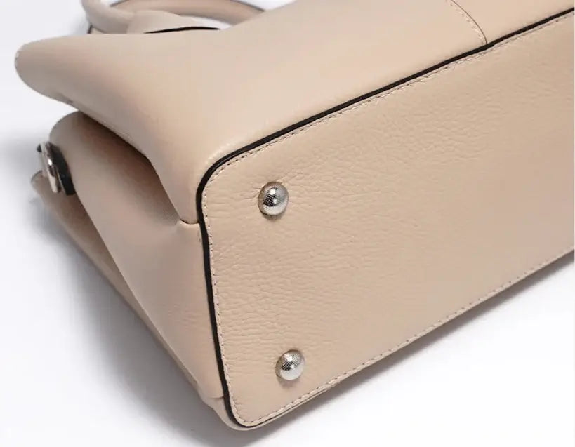 Sac Tote MILES en cuir grainé beige, vue du dessous avec rivets en métal, design élégant et fonctionnalités pratiques.