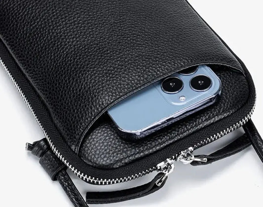 Sac pochette cuir grainé noir avec téléphone à l'intérieur, fermeture double zipper et design pratique.