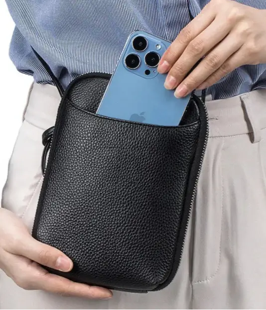 Sac pochette cuir grainé noir avec téléphone, pratique et élégant, idéal pour transporter l'essentiel.