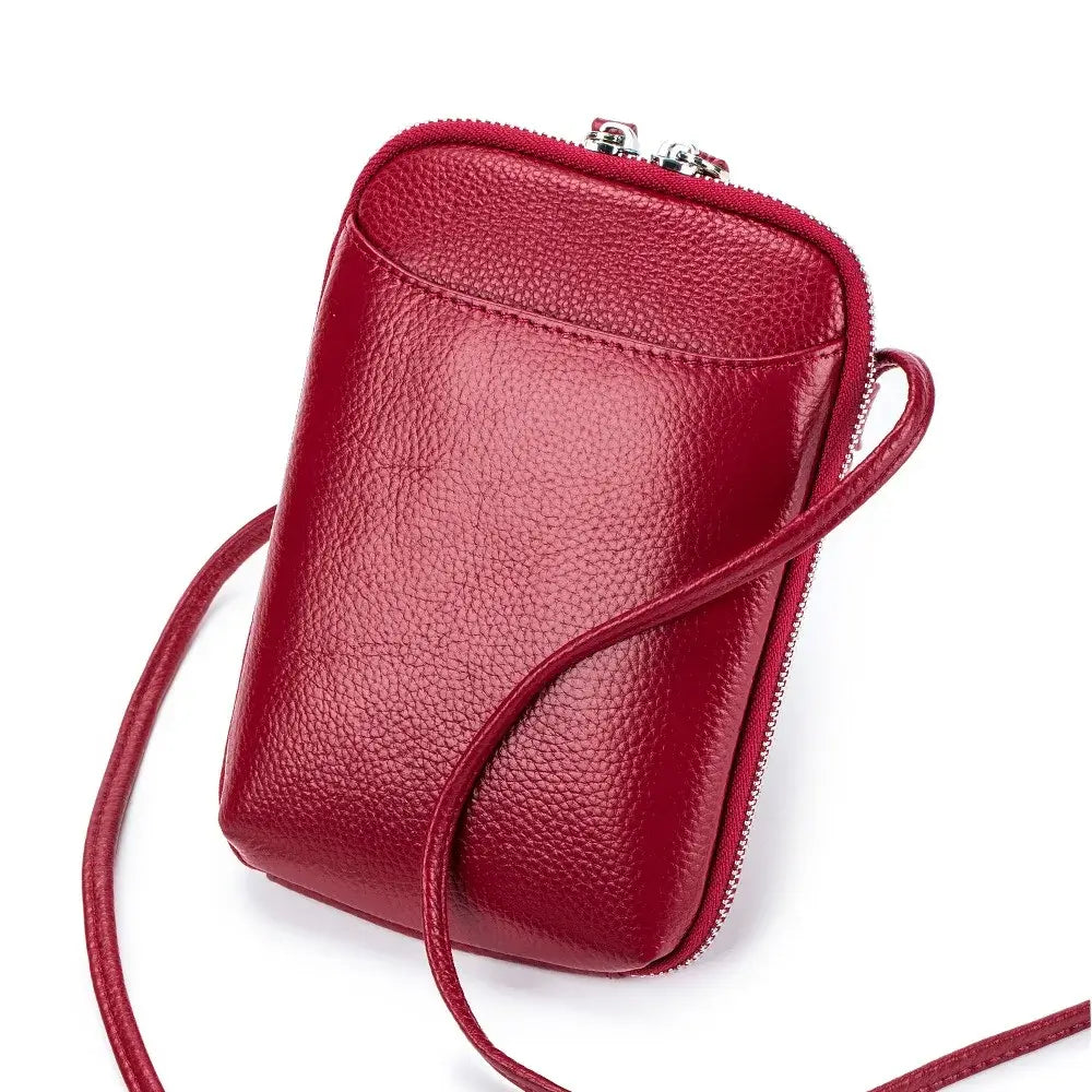Sac pochette cuir grainé rouge avec fermeture double zipper et longue bride d'épaule.