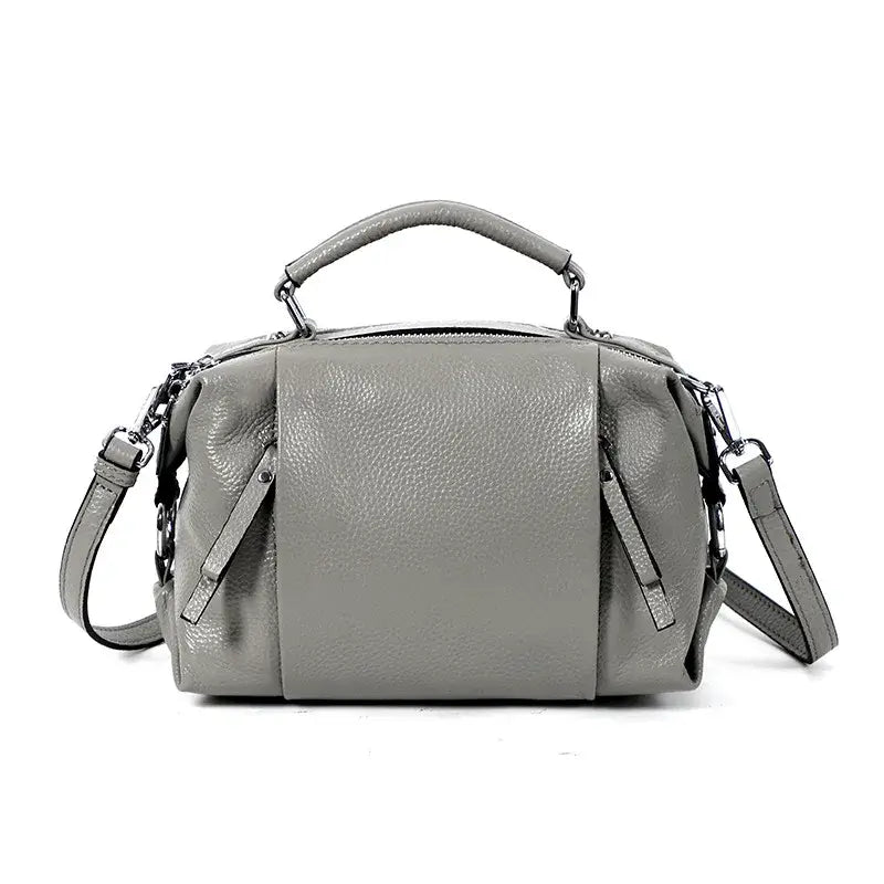 Sac Boston en cuir grainé gris avec double poche intérieure et poches extérieures. Style mi-souple.